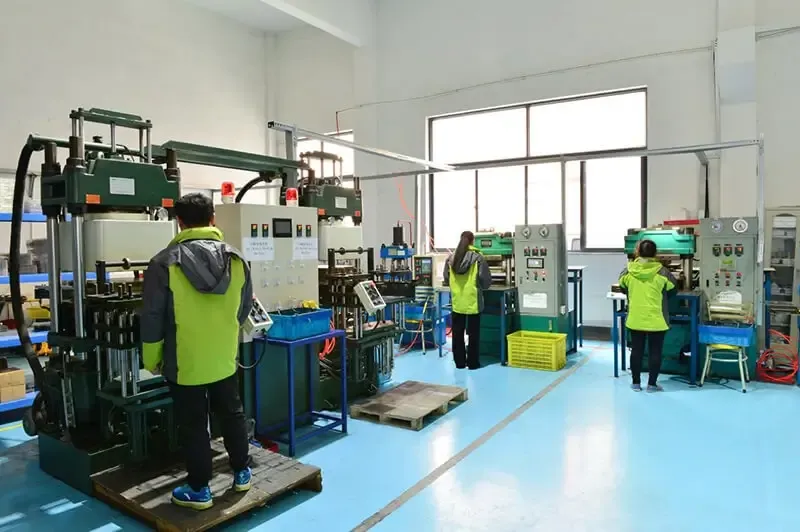 yellow-gray jacketed workers on factory floor