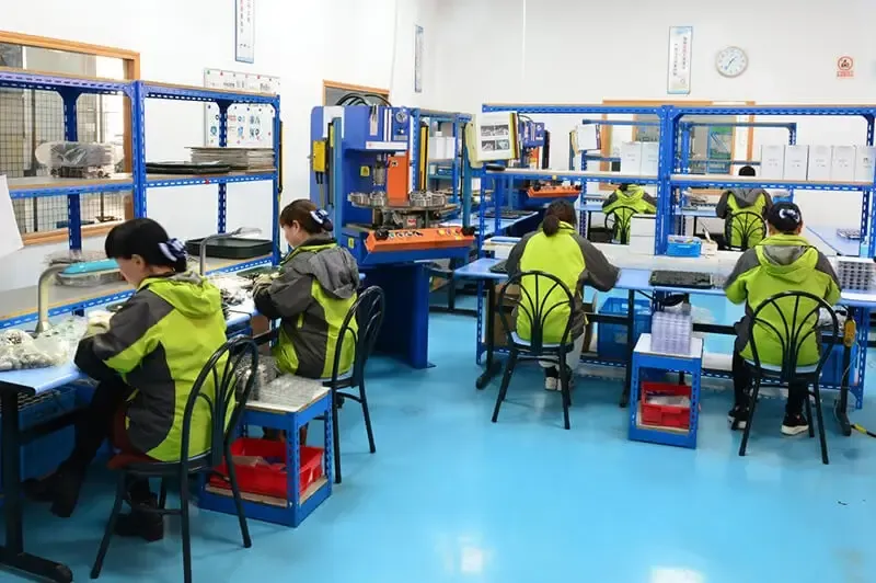 yellow-gray jacketed workers on factory floor