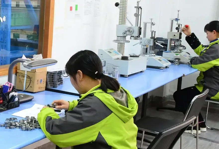 yellow-gray jacketed workers on factory floor